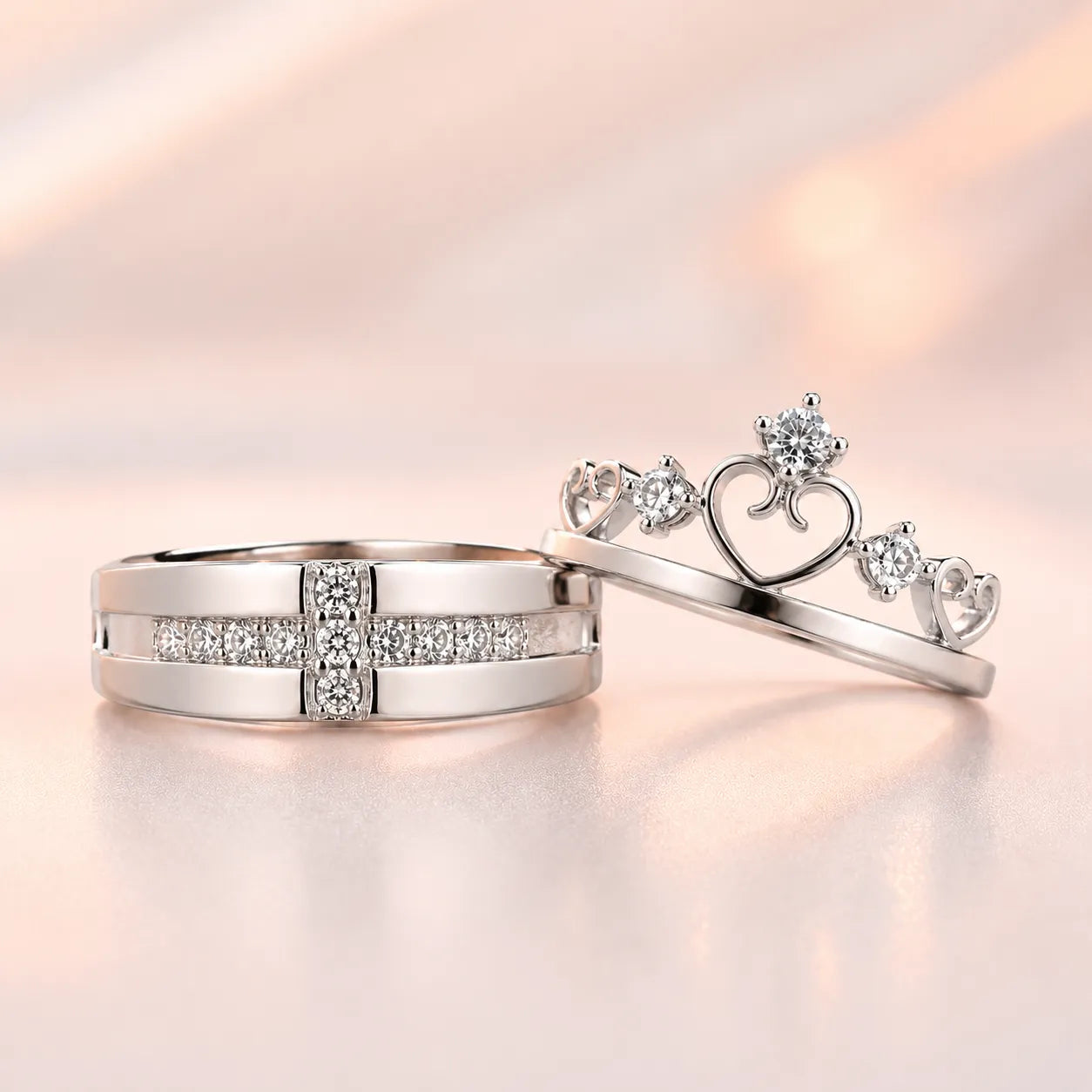 Silver his and hers couple ring set — wide CZ band and crown tiara heart ring displayed together on sparkle background
