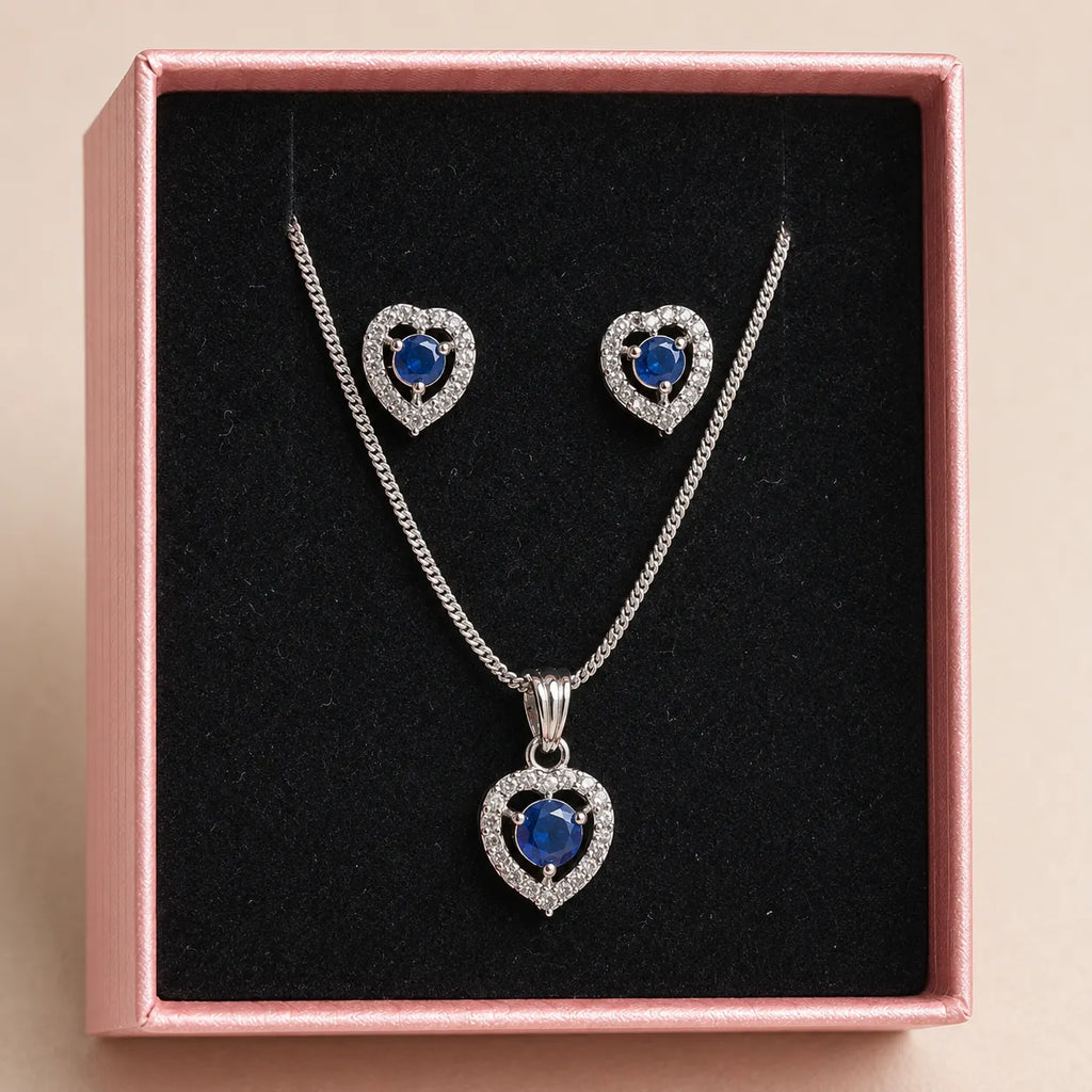 Blue heart pendant necklace and matching earrings displayed in pink gift box