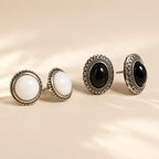 "Black and white stone stud earrings side by side showing silver beaded detail"