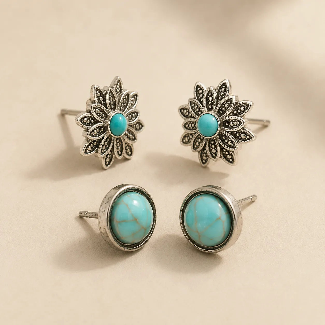 "Close-up of turquoise flower and round stud earrings showing silver detailing and post backs"
