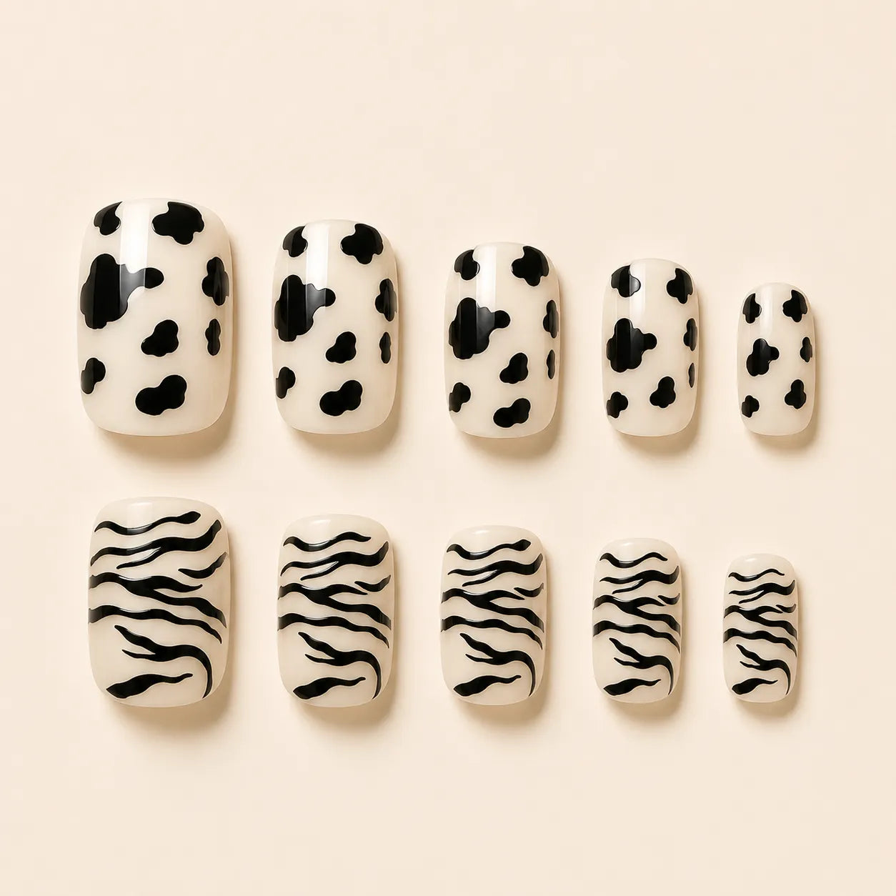 SAVNI cow print and zebra print press-on nails, 10-piece glossy animal print fake nail set on beige background